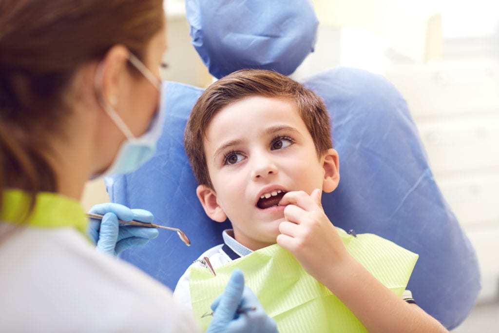 A child with a dentist in a dental office. Dental treatment in a children's clinic.