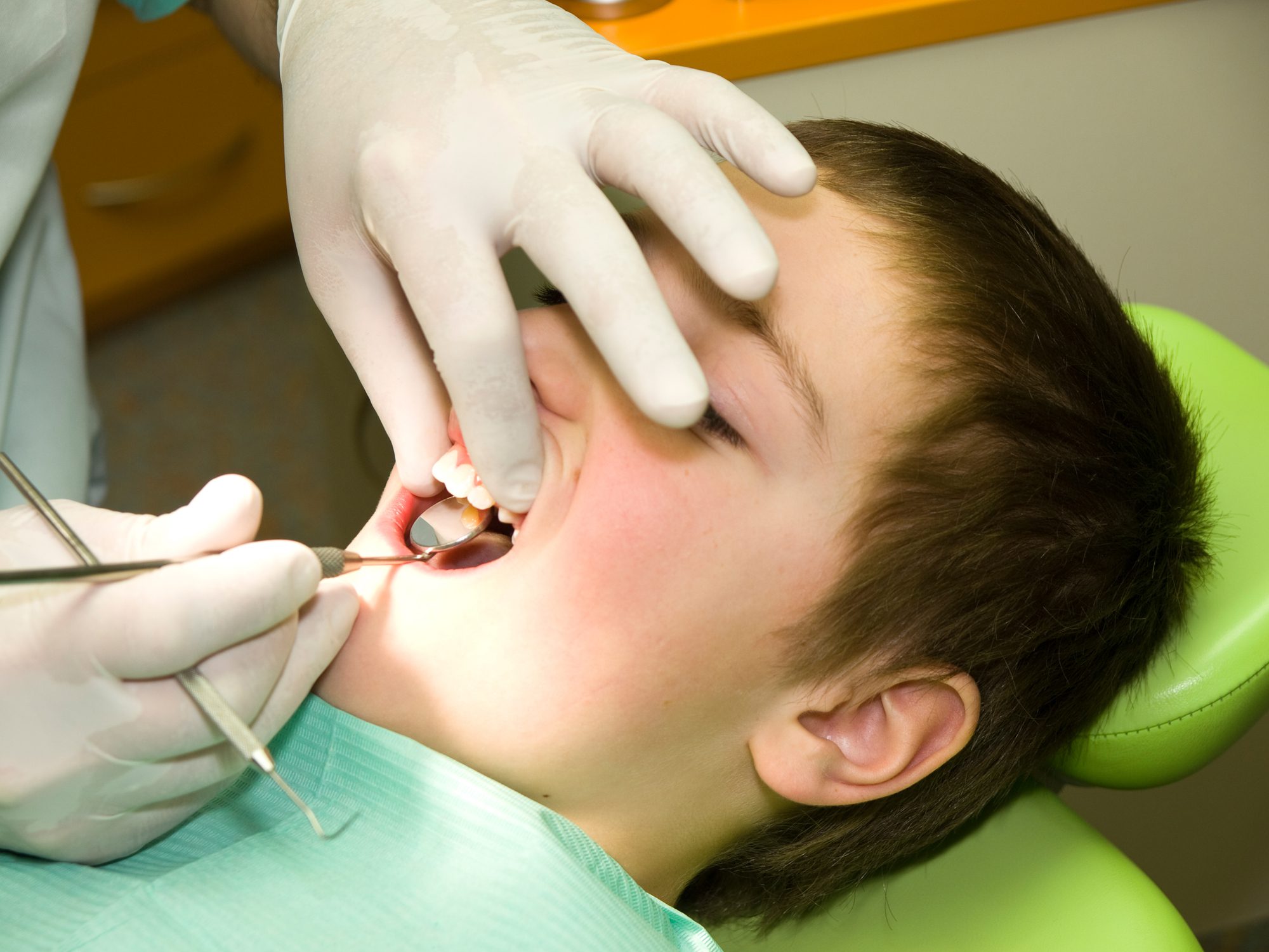 Young boy under dental preventional examination