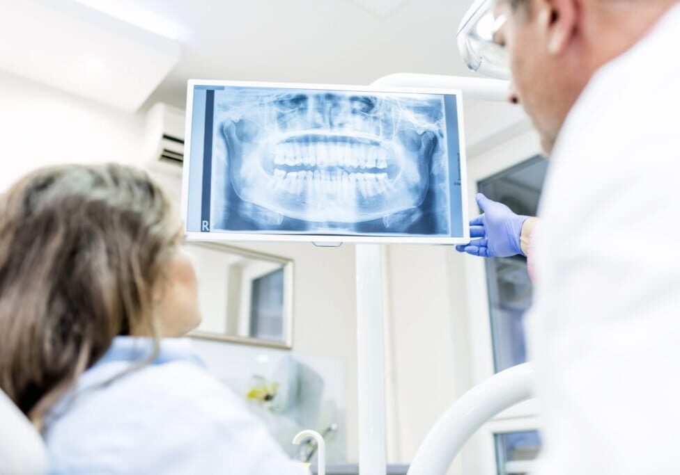 Photo of Dentist showing patient x-ray